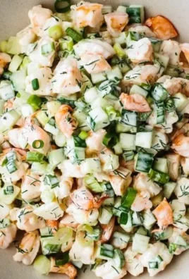 Healthy cucumber shrimp salad served in a bowl with fresh vegetables.