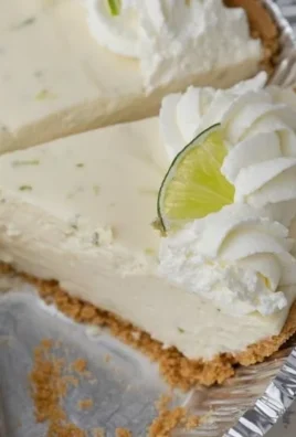 No bake key lime pie topped with whipped cream and lime slices on a plate