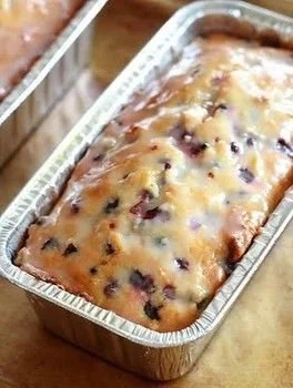 Freshly baked lemon blueberry bread with bright lemon glaze on top