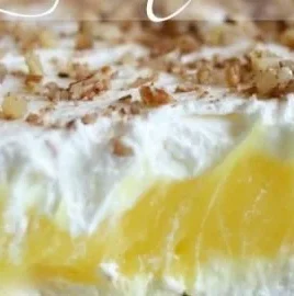 A slice of Luscious Lemon Delight dessert topped with lemon zest and whipped cream
