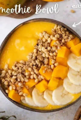 Delicious Mango Smoothie Bowl topped with fruits and nuts