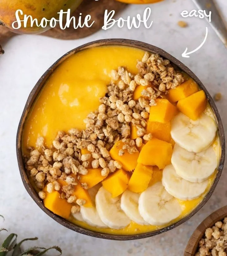 Delicious Mango Smoothie Bowl topped with fruits and nuts