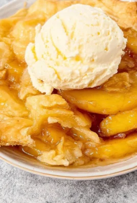 Delicious homemade Peach Cobbler served warm with ice cream