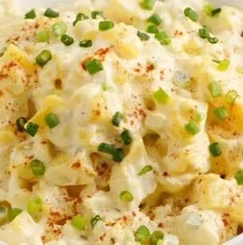Delicious homemade Potato Salad served in a bowl with fresh ingredients.