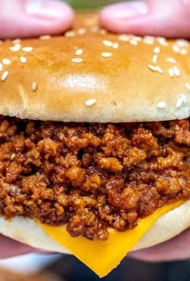 Slow Cooker Sloppy Joes served on a bun with a side of pickles