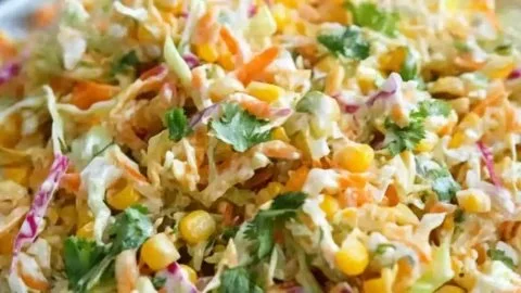 Bowl of spicy corn slaw with fresh vegetables for a summer dish