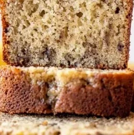 Slice of fresh banana bread on a wooden table