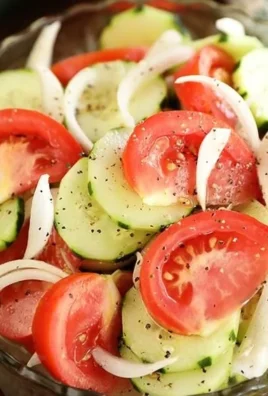 Fresh Tomato, Cucumber, and Onion Salad in a bowl, garnished with herbs.